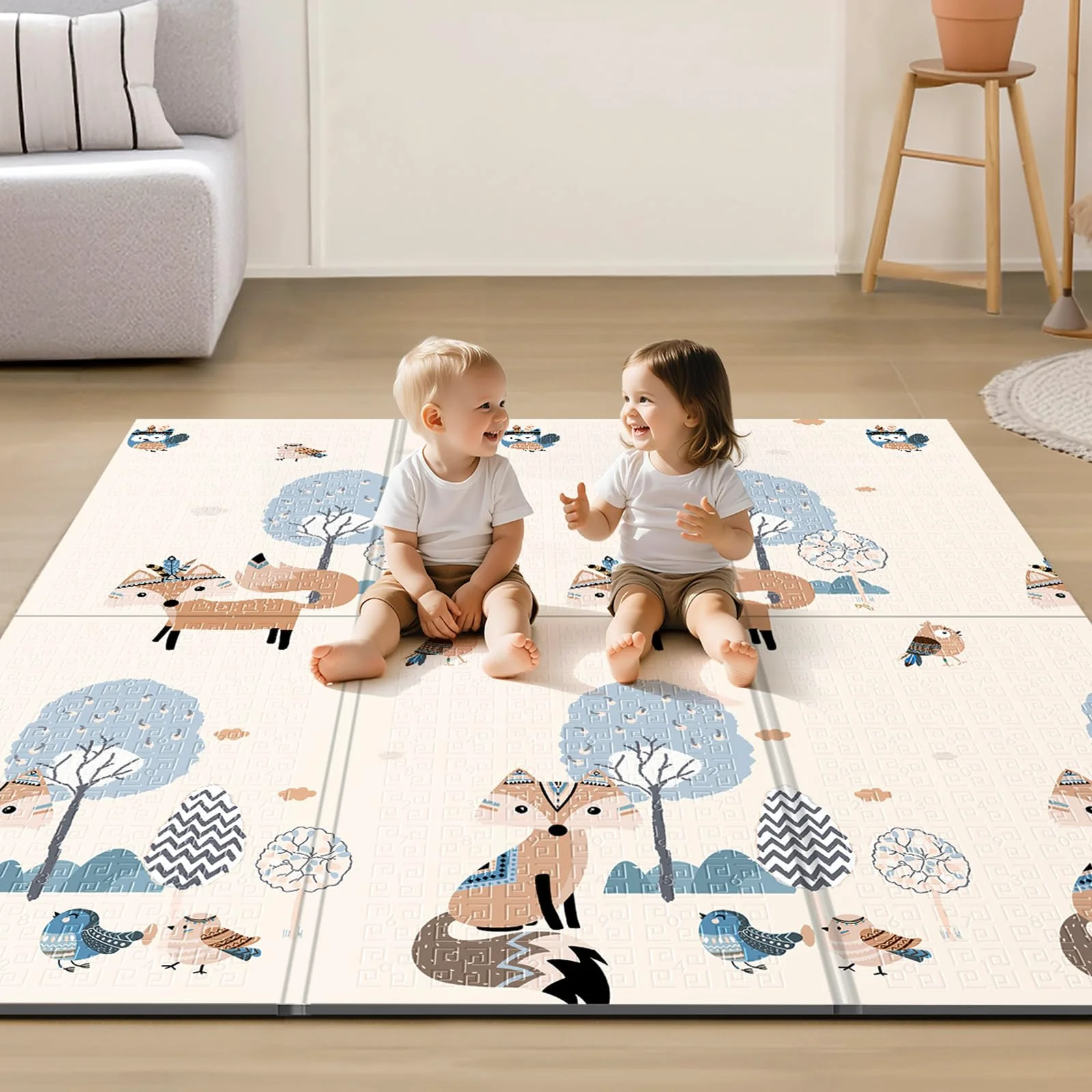 Two children on a fox and bear play mat